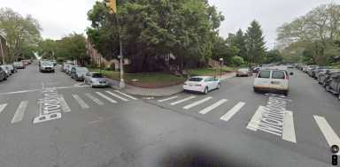 Brooklyn intersection during the day with cars parked on the street